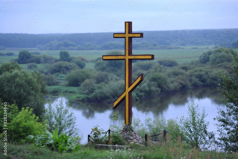 Monument. Religion. Christian cross on a hill near the river Monument. Religion. Christian cross on a hill near the river