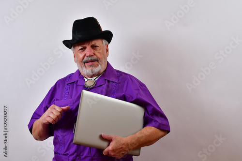 Elegant old man holding his closed laptop computer.