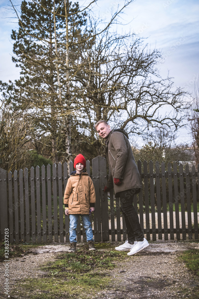 Fototapeta premium Father and son closing their wooden gate in a house in a cozy European city