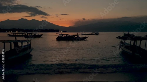 Zoom back shot of boats parked in the harbor during sunset slomo