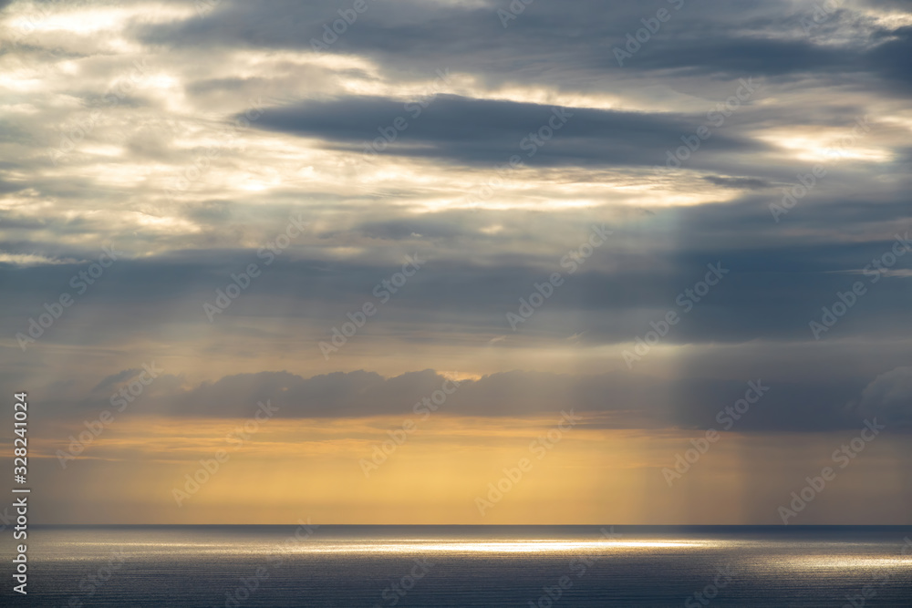 Long aerial view of gray evening clouds over Tasman sea coast at Piha with run rays