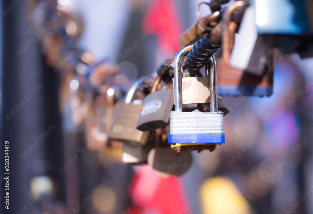  Closeup of a  blue padlock hanging on chain link of the bridge / Fence