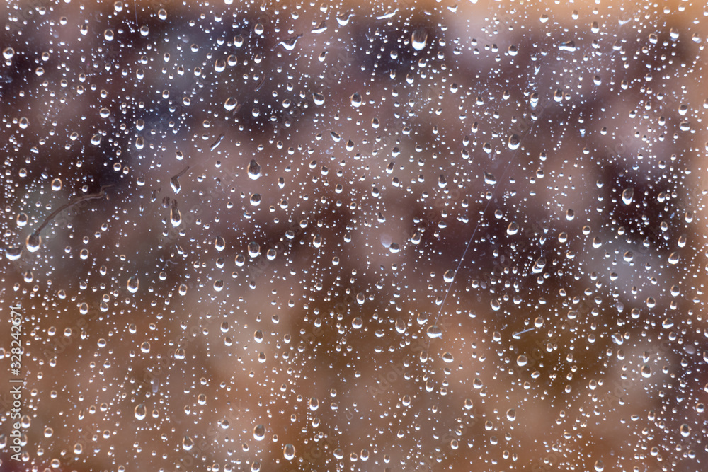 image of raindrops on glass with beautiful natural colors background behind.