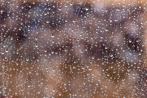 image of raindrops on glass with beautiful natural colors background behind.
