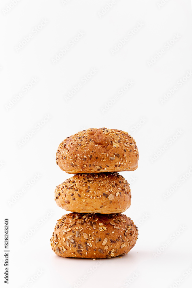 Pile of wholegrain baked buns on white background Pile of wholegrain baked buns on white background