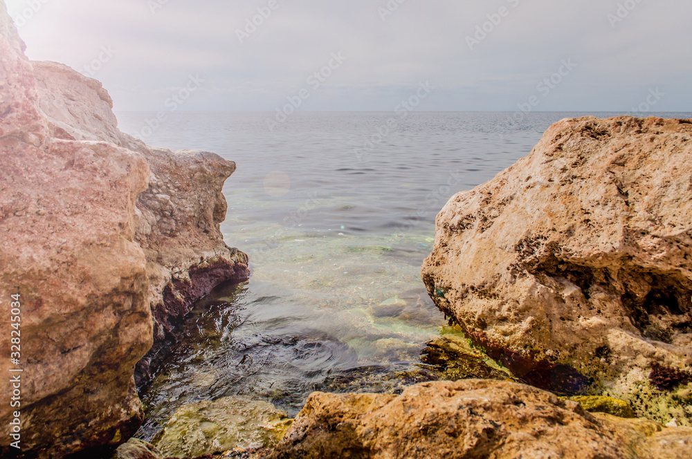 Black Sea red rocks coastline. Cape Chersonesos wild beach in Sevastopol, Russia.