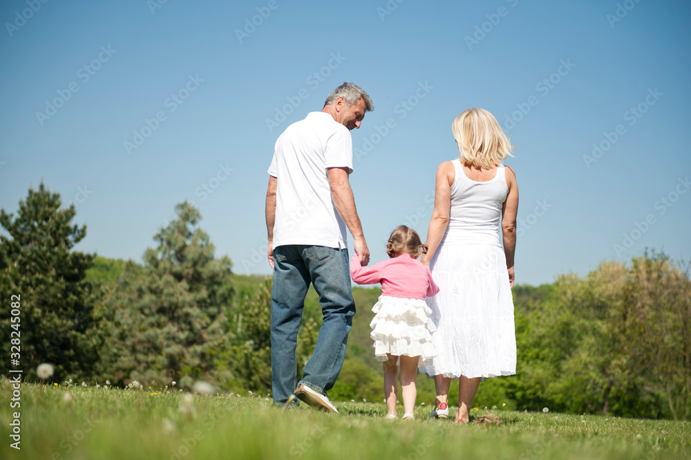 Happy senior couple with child in a park