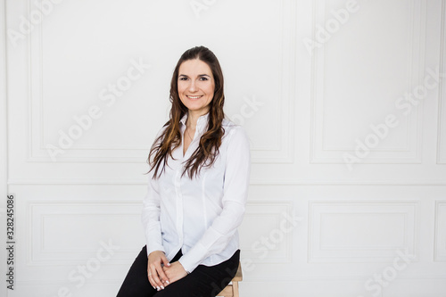 Portrait of a girl in a bright interior, a girl of European appearance sitting on the couch, Manager, freelancer