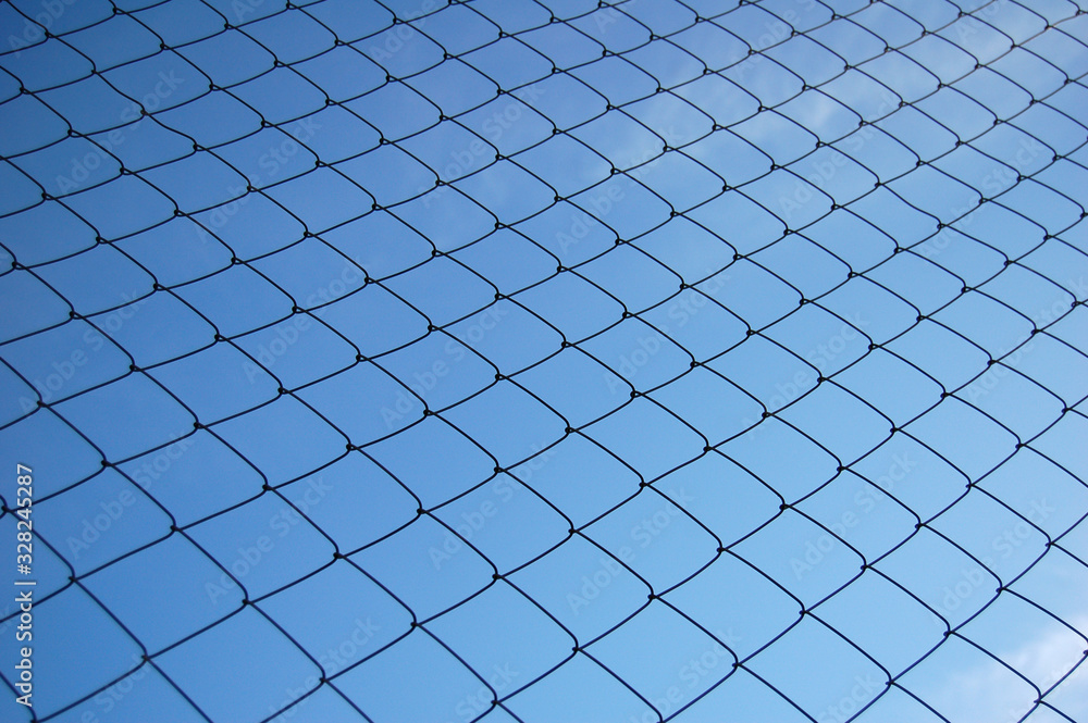 Metallic net with blue sky background Metallic net with blue sky background
