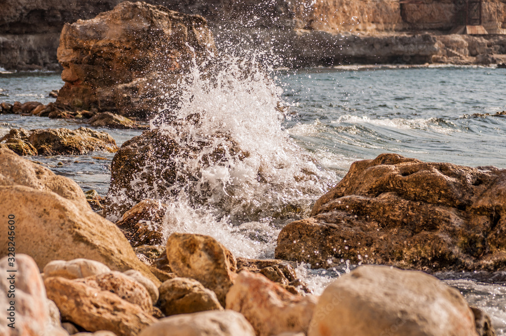 Splitting waves against picturesque rocks in the sea Splitting waves against picturesque rocks in the sea