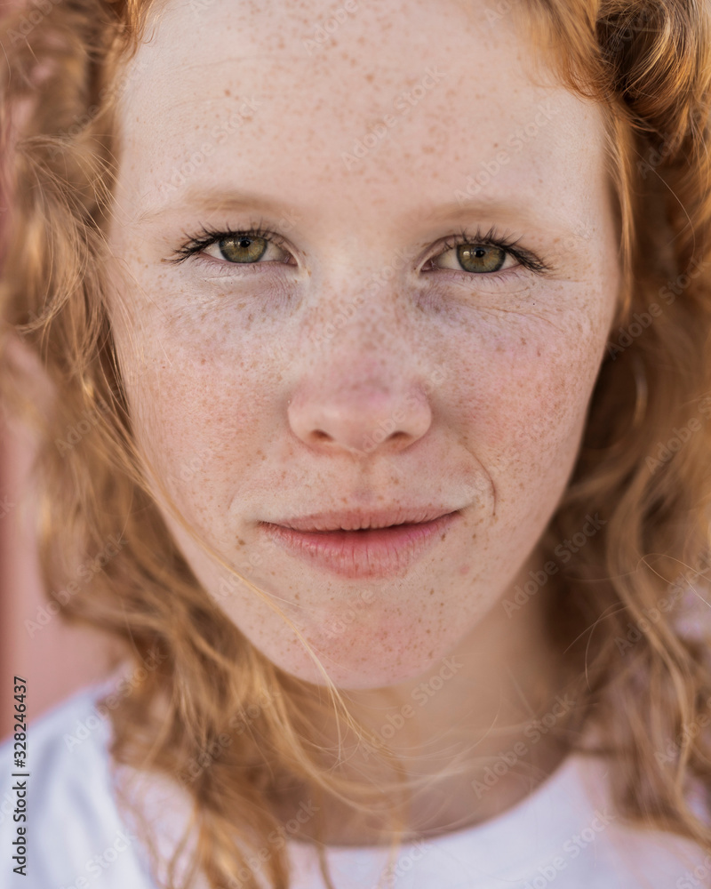 Close-up girl with freckles looking at camera Close-up girl with freckles looking at camera