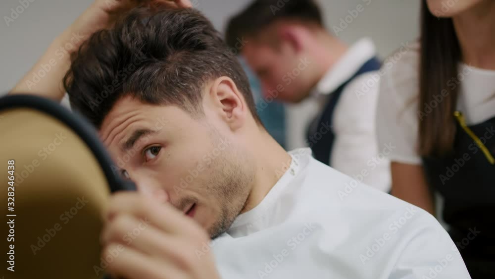 Handheld view of handsome man in hair salon. Shot with RED helium camera in 8K Handheld view of handsome man in hair salon. Shot with RED helium camera in 8K