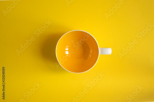 Fototapeta yellow cup on yellow background