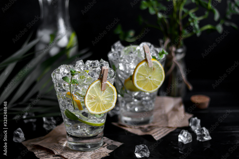 Refreshing summer alcoholic cocktail Margarita with crushed ice, lime and mint for decoration. Vodka splash. On a dark wooden background. On the leaves of the newspaper.