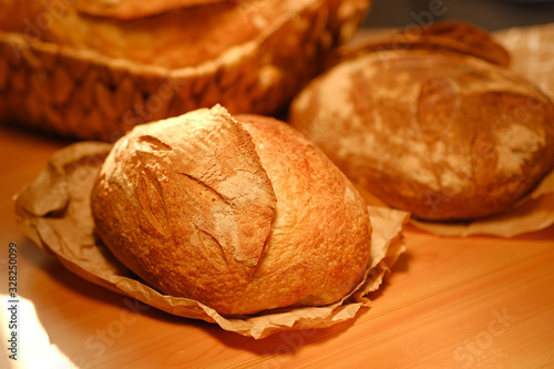 Assortment of baked bread on wooden table background. Bread background, top view of white, black and rye loaves. Healthy food. 