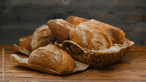 Assortment of baked bread on wooden table background. Bread background, top view of white, black and rye loaves. Healthy food. 