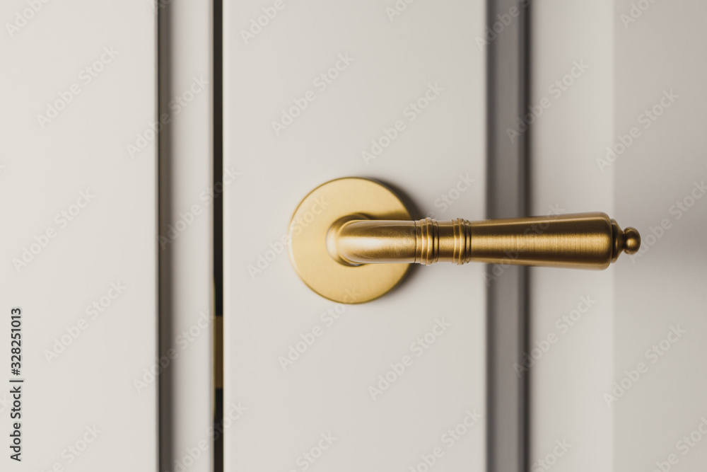 Obraz premium Brushed gold modern design in vintage style door handle on a white door.