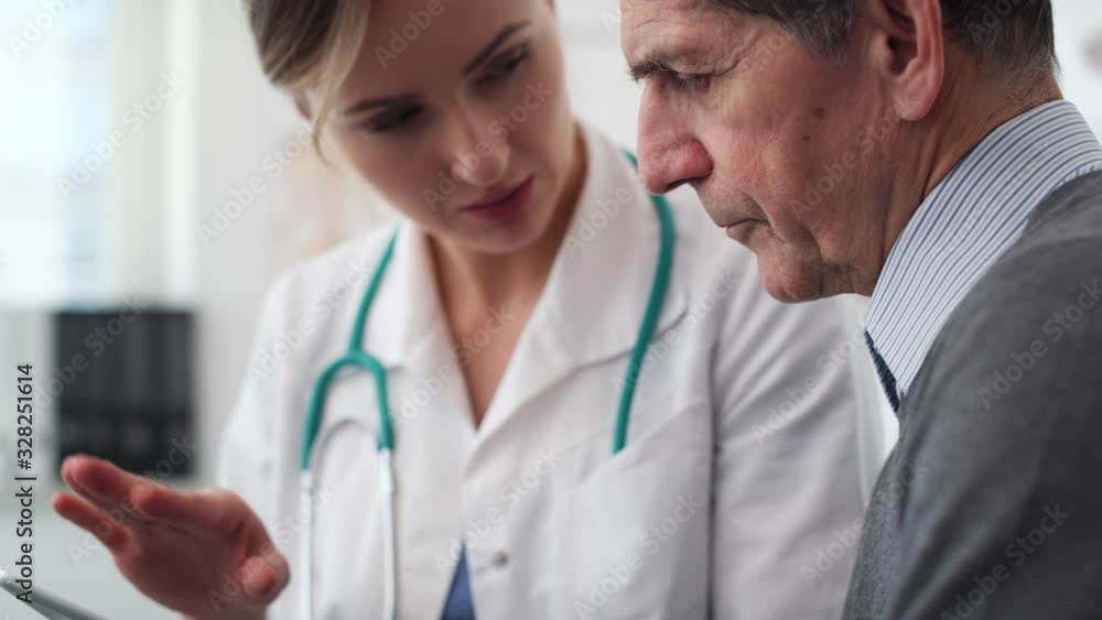 Handheld view of doctor showing examination results on the digital tablet. Shot with RED helium camera in 8K Handheld view of doctor showing examination results on the digital tablet. Shot with RED helium camera in 8K