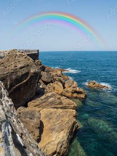 View from the rocks of the sea and rainbow in San Sebastian Spain