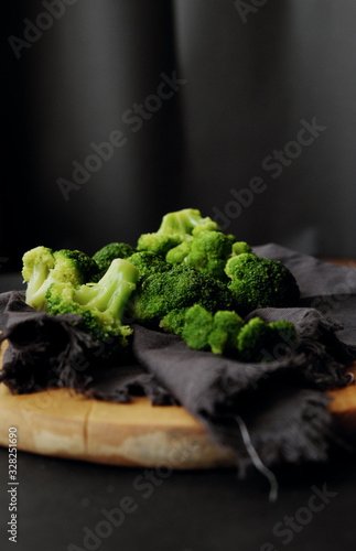 healthy breakfast: Fresh raw broccoli on a wooden board on a dark background. 