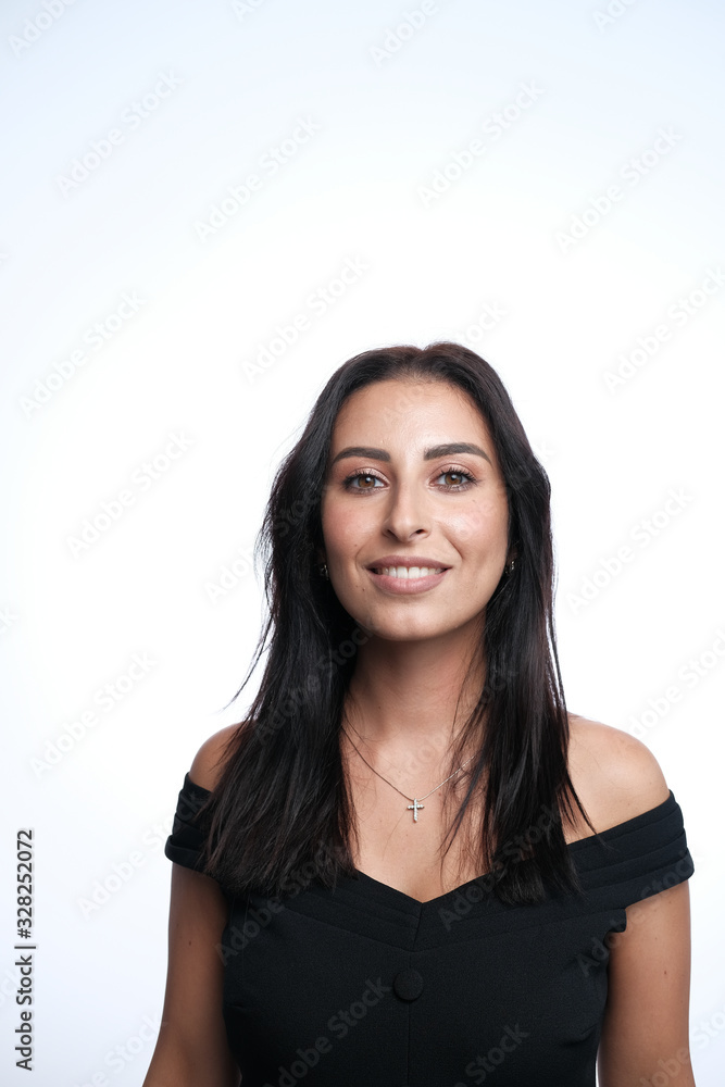 A large portrait of a middle-aged woman (30-35 years old) with dark hair and brown eyes in a black dress on a light background. A large portrait of a middle-aged woman (30-35 years old) with dark hair and brown eyes in a black dress on a light background.