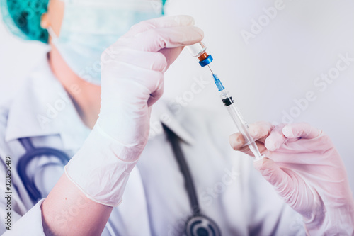 Vaccine bottle and syringe in a doctors hands close-up.  Ncov-19/ Coronavirus concept. 
