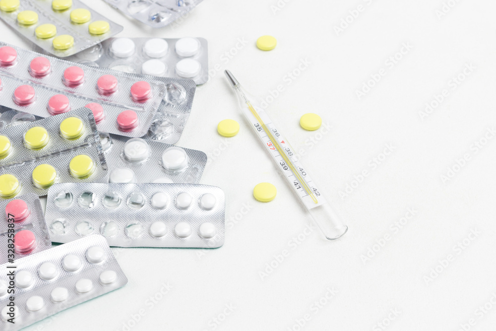 Pill to treat colds and thermometer. Cold remedies. Medical concepts and medicines Pill to treat colds and thermometer. Cold remedies. Medical concepts and medicines