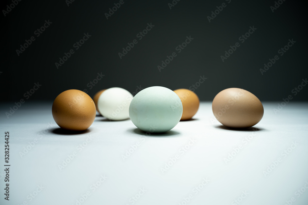Many eggs are in a white table in the dark. Many eggs are in a white table in the dark.
