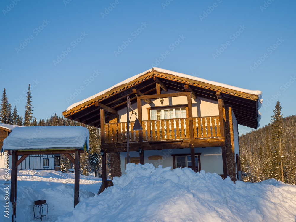 Wooden two-story Alpine-style house. Hotel in the ski resort Gornaya Salanga. Winter day Wooden two-story Alpine-style house. Hotel in the ski resort Gornaya Salanga. Winter day
