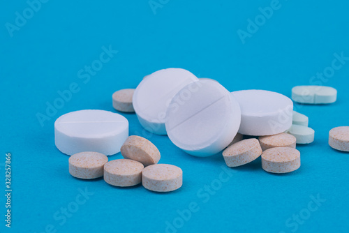 White round tablets are scattered on a blue background