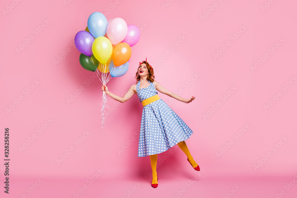 Full size photo of positive cheerful lady feel carefree enjoy fifty style rest relax hold many baloons laugh wear tights blue good look clothes isolated over pink color background
