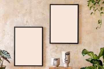 Interior design of living room with two black mock up poster frames, shelf, vases, plants and elegant personal accessoreis. Grunge wall. Stylish home decor. Wabi sabi concept.Template. 