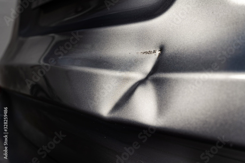 Foto A dent in the body of a silver car in exciting light.