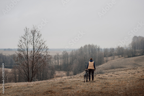owner and weimaraner dog standing outdoors, rear view © ksuksa