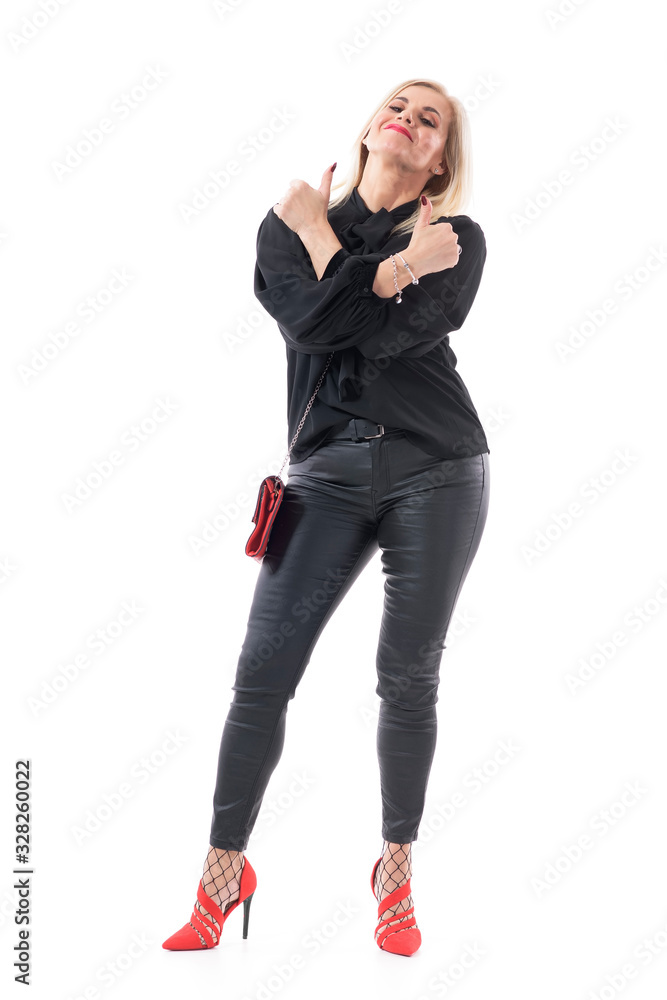 Self assured confident middle aged woman endorsing and approving with thumbs up and crossed hands. Full body length isolated on white background. Self assured confident middle aged woman endorsing and approving with thumbs up and crossed hands. Full body length isolated on white background.