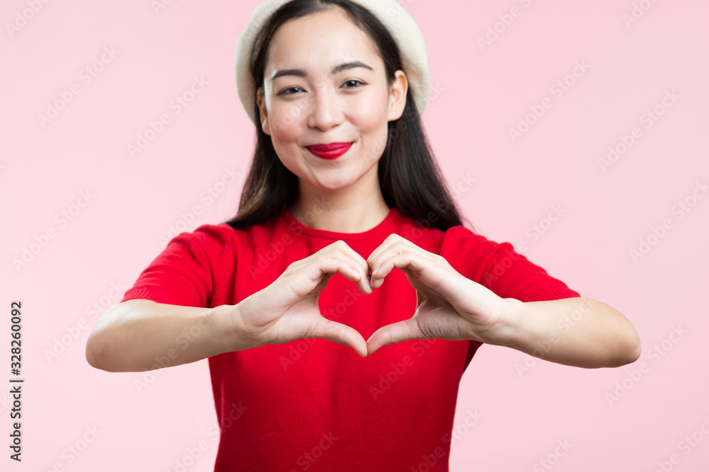 Front view woman with red lips showing heart shape with hands Front view woman with red lips showing heart shape with hands
