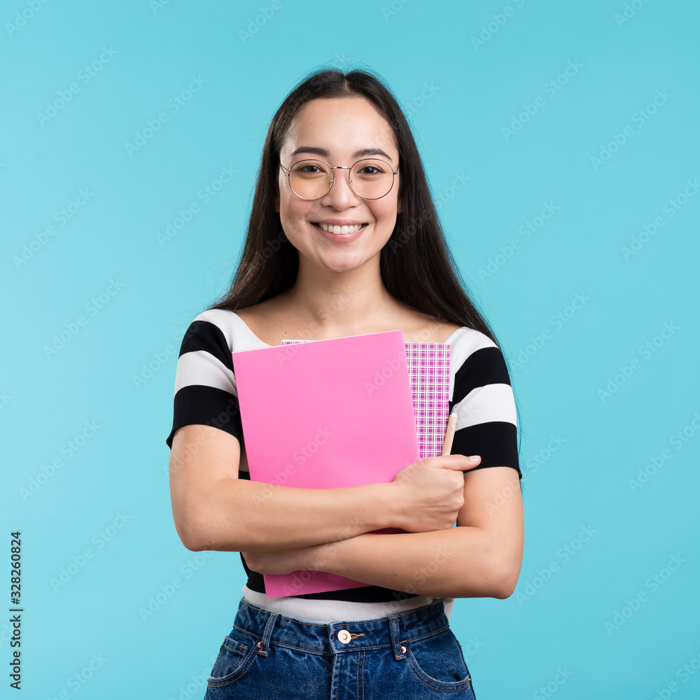 Smiling woman holding stack of books Smiling woman holding stack of books