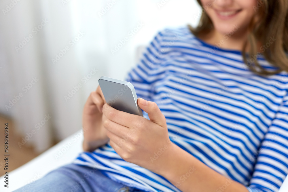 technology and people concept - close up of smiling teenage girl using smartphone at home technology and people concept - close up of smiling teenage girl using smartphone at home