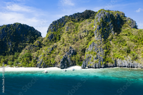 View from above, stunning aerial view of the Entalula Beach, a white sand beach bathed by a crystal clear sea. Entalula island, Bacuit Bay, El Nido, Palawan, Philippines.