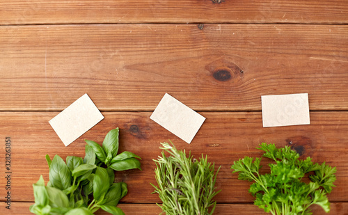 greens, spices or medicinal herbs concept - bunches of parsley, basil and rosemary on wooden boards