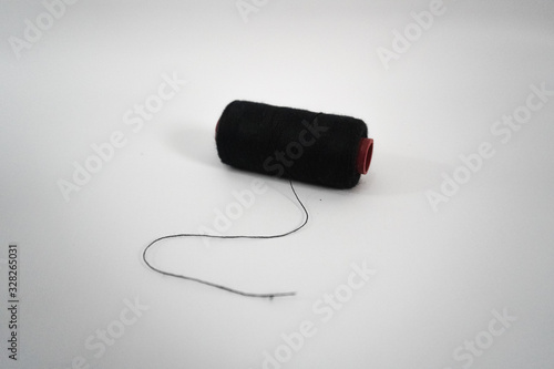 black sewing thread on a white background