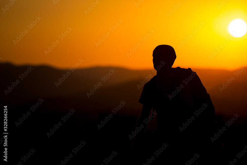 Silhouette of a tourist on a sunset background