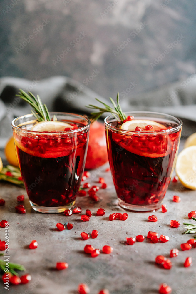 Pomegranate drink in a glass with lemon and rosemary Pomegranate drink in a glass with lemon and rosemary