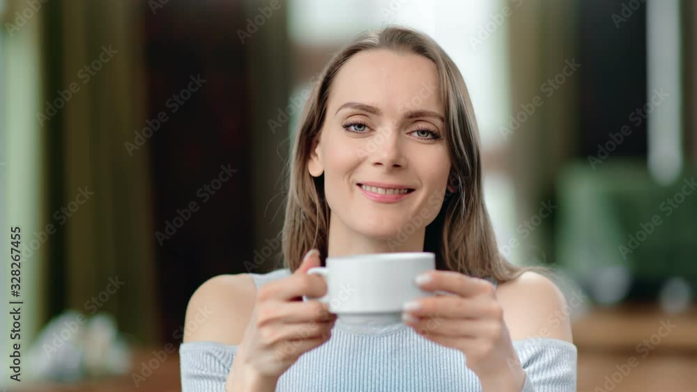 Portrait of beautiful woman drinking hot tea smiling posing at cafe. Close up shot on 4k RED camera Portrait of beautiful woman drinking hot tea smiling posing at cafe. Close up shot on 4k RED camera