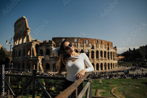 Famous Colosseum in Rome, Italy. Travel girl smiling and posing against Roman colosseum. Spring holidays and vacation in Europe. © eduard