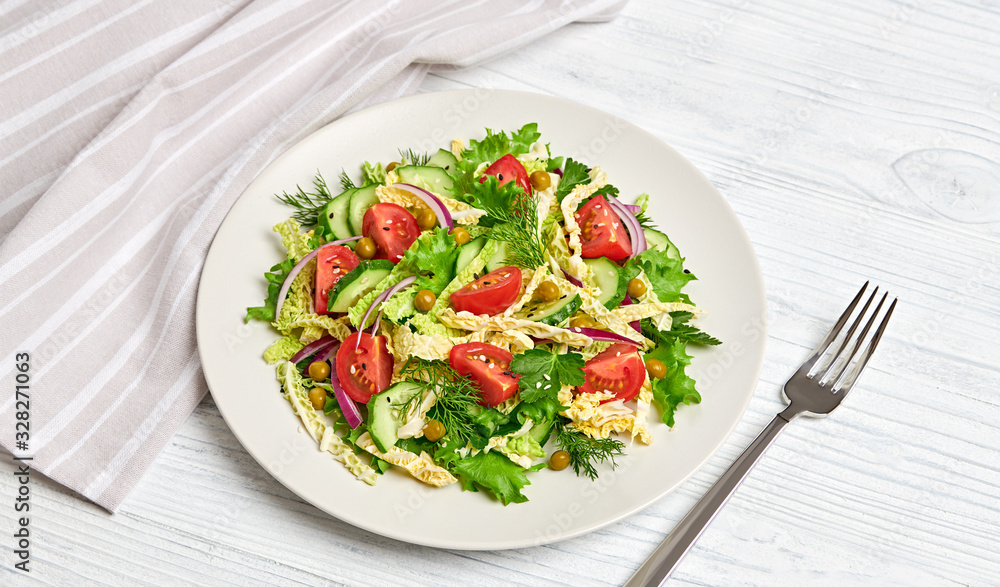 Fresh salad with cherry tomatoes, savoy cabbage, cucumeber on dish. Healthy summer salad vegetarian meal concept. Tasty mixed leaves, tomatoes and mix vegetable salad on white wood Fresh salad with cherry tomatoes, savoy cabbage, cucumeber on dish. Healthy summer salad vegetarian meal concept. Tasty mixed leaves, tomatoes and mix vegetable salad on white wood
