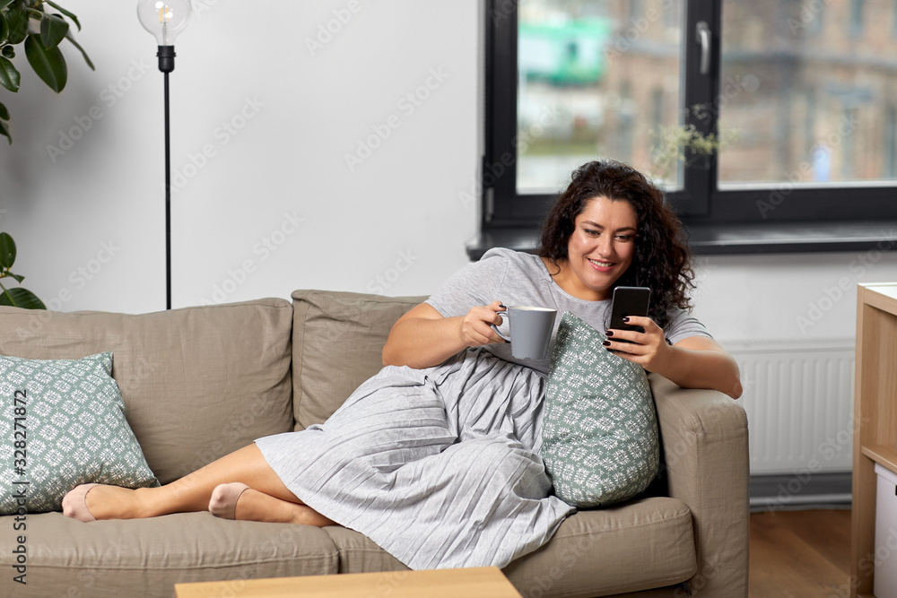 technology, leisure and people concept - happy smiling woman with smartphone drinking tea or coffee at home technology, leisure and people concept - happy smiling woman with smartphone drinking tea or coffee at home
