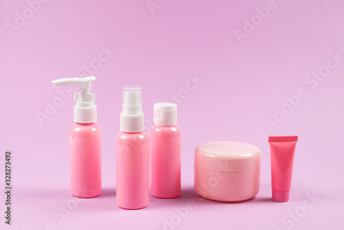 Pink plastic bottles for hygiene products, cosmetics, hygiene products on a pink background. © Nikolay