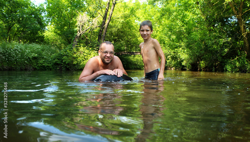 Dad and son play in the river in the hot summer. Dad and son play in the river in the hot summer.