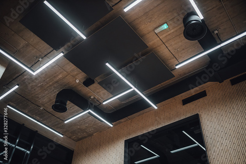 View on modern led lightning hanging from ceilings, industrial building concrete texture photo